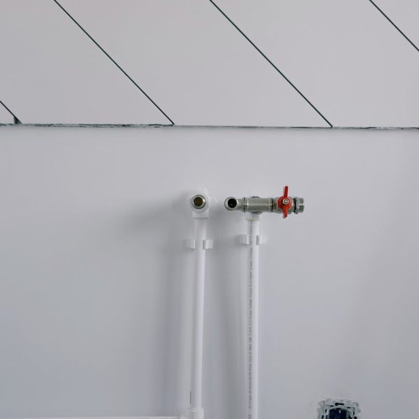 pexels-photo-5691473-5691473 White wall with minimalist plumbing pipes and diagonal lines